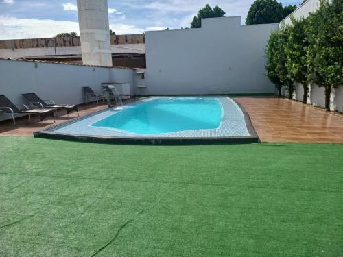 a large swimming pool on a building with a green lawn at Hotel e Locadora Vizon in Vilhena