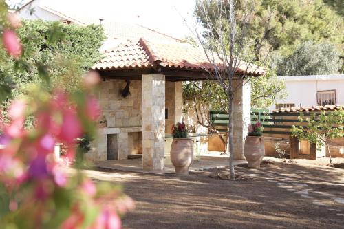 a building with a pavilion with two large flower pots at Perfect home for Relaxing in Artemida