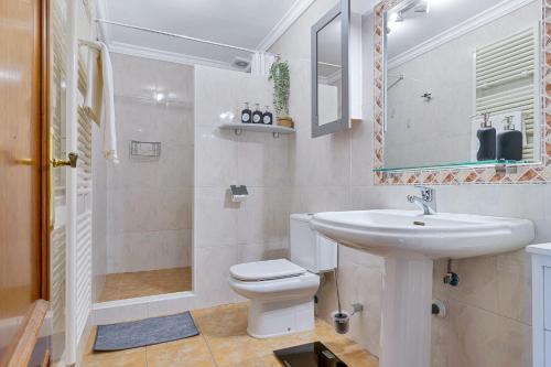 Monda Heights close to Marbella في موندا: حمام مع حوض ومرحاض ومرآة
