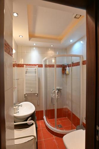 uma casa de banho com um chuveiro e um lavatório. em Cozy Apartment Νear Nea Paralia of Thessaloniki em Tessalônica