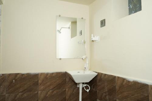 a bathroom with a sink and a mirror at Dwarkesh Farm&Resort in Somnath