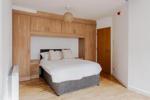 a bedroom with a large bed with a wooden headboard at Lively Liverpool Living -1BR Flat Near Cavern Club - Pass The Keys in Liverpool