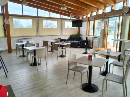 een restaurant met tafels en stoelen in een kamer met ramen bij B&B Caffè in Noci