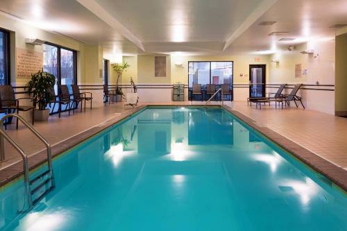 a swimming pool with chairs and tables in a building at SpringHill Suites Louisville Downtown in Louisville