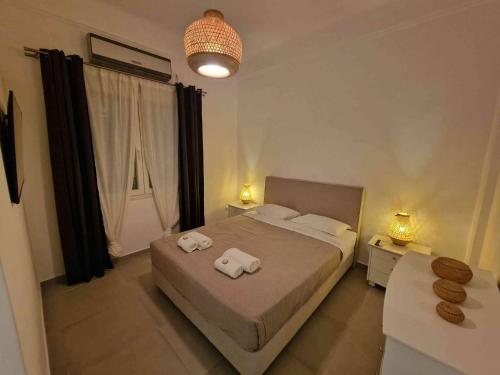 a bedroom with a bed with two towels on it at Karaoulanis rooms in Andros