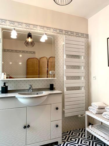 une salle de bain avec un lavabo et un miroir dans l'établissement La Maison VH, à Mont-de-Marsan