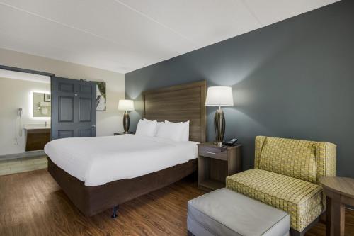 a hotel room with a bed and a chair at Quality Inn Asheville Airport in Fletcher