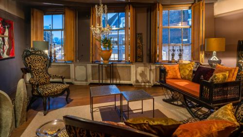 un soggiorno con divano, sedie e finestre di De Ginkgo in het hart van Hoorn a Hoorn