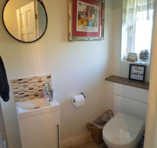 a bathroom with a sink and a mirror and a toilet at Entire house, Crambeck,Welburn, near Castle Howard in Welburn