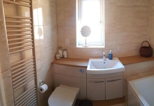 a bathroom with a sink and a toilet and a window at Entire house, Crambeck,Welburn, near Castle Howard in Welburn