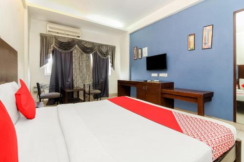 1 dormitorio con cama, escritorio y ordenador en Collection O Hotel Happy Stay Near Hyderabad Central en Ameerpet