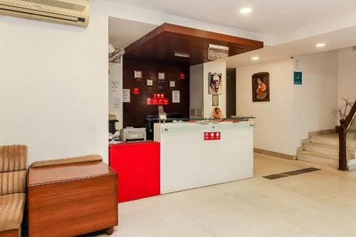 Habitación con nevera blanca y encimera roja. en Collection O Hotel Happy Stay Near Hyderabad Central en Ameerpet
