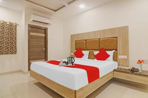 a bedroom with a large bed with red pillows at OYO Devi Residency Near Mahakali Temple in Hyderabad