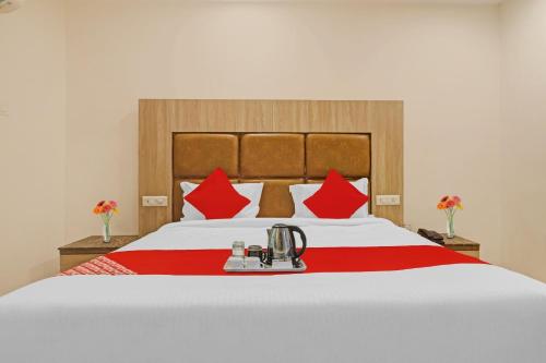 um quarto com uma cama grande e almofadas vermelhas em OYO Devi Residency Near Mahakali Temple em Hyderabad