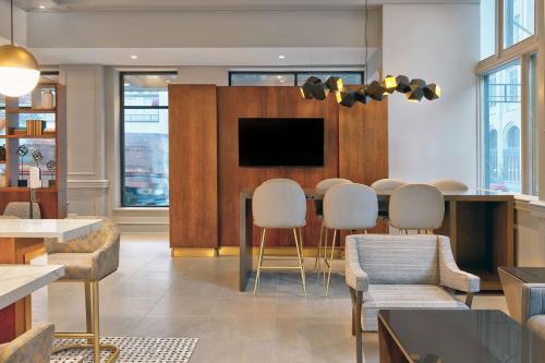 a living room with a table and chairs and a tv at Le Méridien St. Louis Downtown in Saint Louis