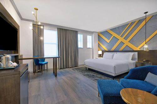 a hotel room with a bed and a living room at Le Méridien St. Louis Downtown in Saint Louis