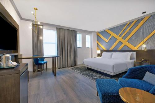 Una habitación de hotel con una cama y una sala de estar. en Le Méridien St. Louis Downtown, en Saint Louis