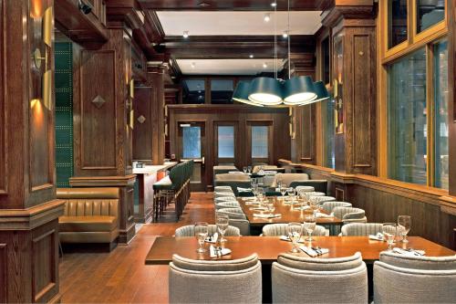a restaurant with wooden walls and tables and chairs at Le Méridien St. Louis Downtown in Saint Louis