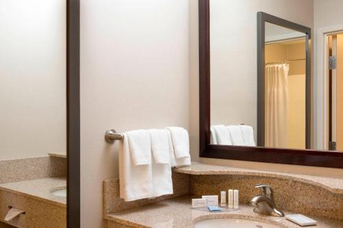 a bathroom with a sink and a mirror at SpringHill Suites Midland in Midland