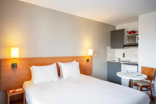 a hotel room with a bed and a small kitchen at Séjours & Affaires Créteil Le Magistere in Créteil