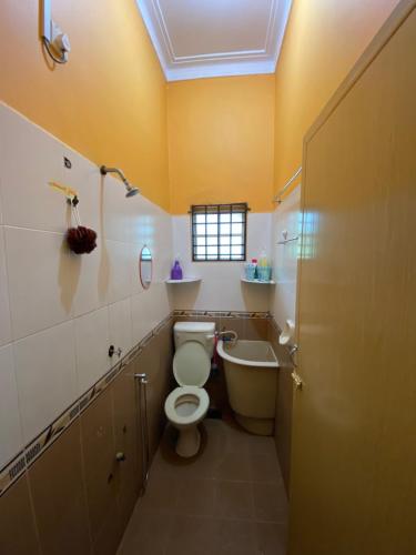 a bathroom with a toilet and a tub and a sink at Idaman homestay in Bukit Mertajam