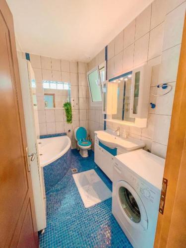 a bathroom with a tub sink and a washing machine at Dream Villa in Paleo Tsifliki