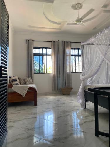 una camera con letto e ventilatore a soffitto di Maisha Villa Nungwi a Banda Kuu