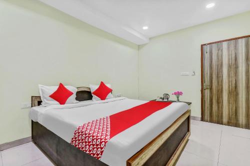 a bedroom with a large bed with red pillows at OYO Flagship Govind Guest House in Gorakhpur
