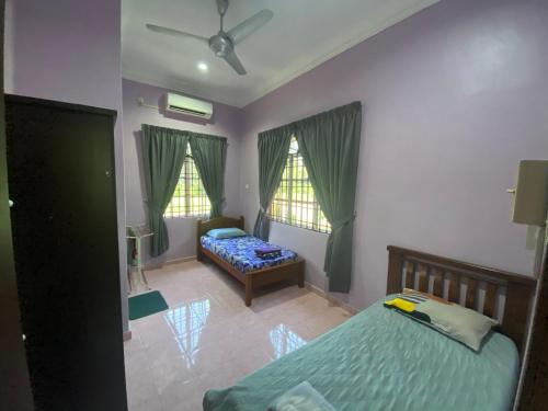 a bedroom with a bed and a couch and two windows at Idaman homestay in Bukit Mertajam