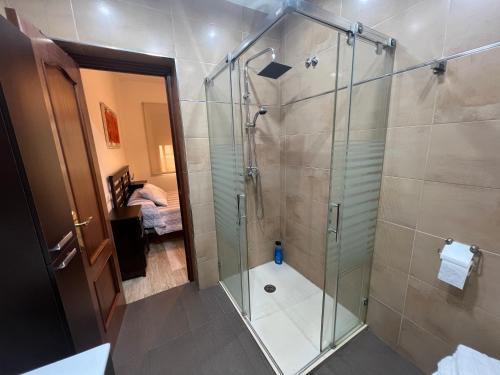 uma casa de banho com um chuveiro e uma porta de vidro em Apartamento Duplex El Porche em Paradas