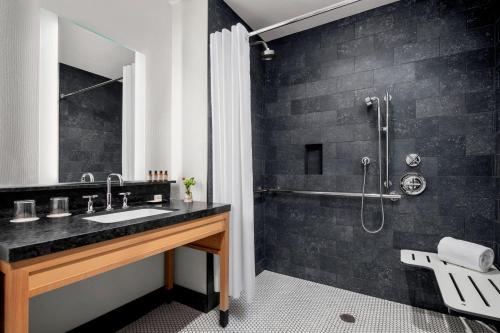 a bathroom with a sink and a shower at The Oaklander Hotel, Autograph Collection in Pittsburgh