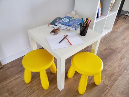 a white table with two yellow chairs and a desk at Holiday home Vinovilla in Kutjevo