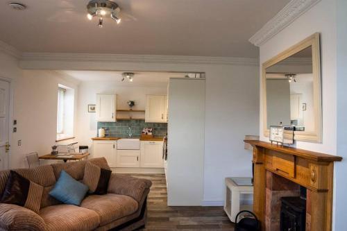 a living room with a couch and a kitchen at Grapevine Getaway in Lincolnshire