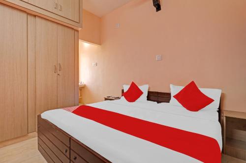 a bedroom with a large bed with red pillows at Highways Residency in Madurai