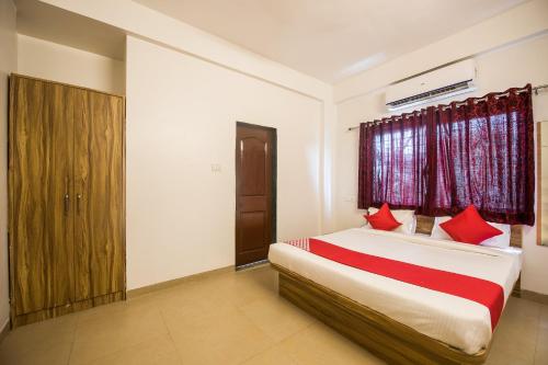 um quarto com uma cama com almofadas vermelhas em OYO Primrose Regency Near Amanora Mall em Kharadi