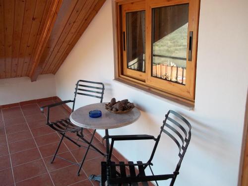 a table and chairs in a room with a window at Epikoureios Apollon in Andritsaina