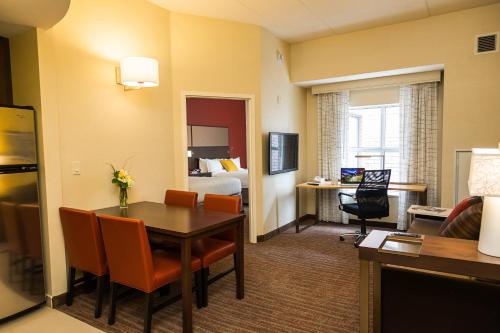 a hotel room with a table and a bedroom at Residence Inn by Marriott Ottawa Airport in Ottawa