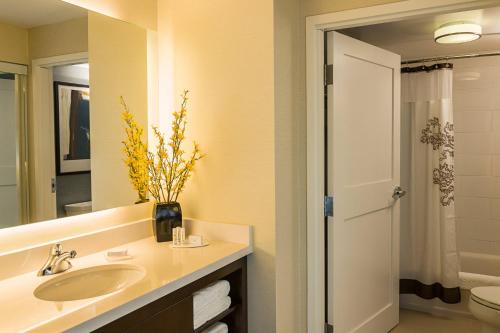 a bathroom with a sink and a toilet and a mirror at Residence Inn by Marriott Ottawa Airport in Ottawa