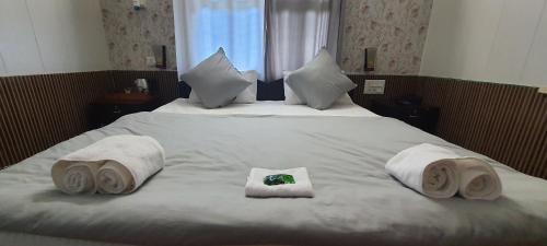 a large bed with towels and pillows on it at Karthik Resorts, Jeolikote Nainital in Nainital