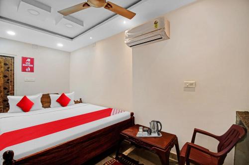 um quarto com uma cama, uma mesa e uma ventoinha de tecto em OYO Pratikshya A1 Residency em Bhubaneshwar