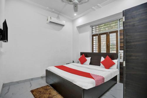 um quarto com uma cama com almofadas vermelhas em Krishna Palace em Vrindavan