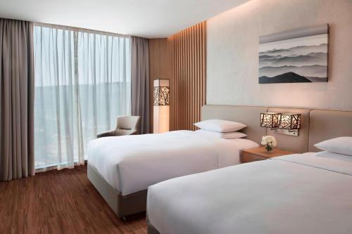 a hotel room with two beds and a window at Courtyard by Marriott Seoul Botanic Park in Seoul