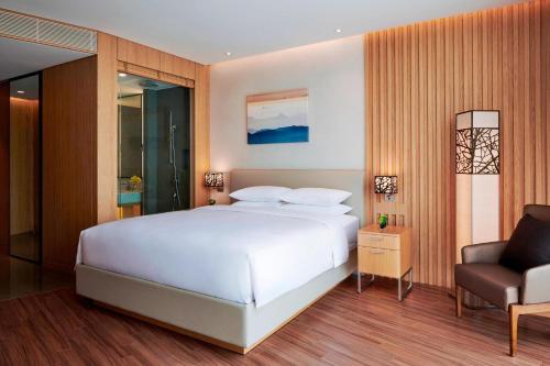 a bedroom with a white bed and a chair at Courtyard by Marriott Seoul Botanic Park in Seoul