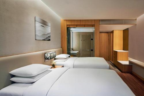 a hotel room with two beds and a bathroom at Courtyard by Marriott Seoul Botanic Park in Seoul