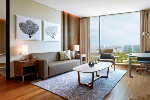 a living room with a couch and a table at Courtyard by Marriott Seoul Botanic Park in Seoul