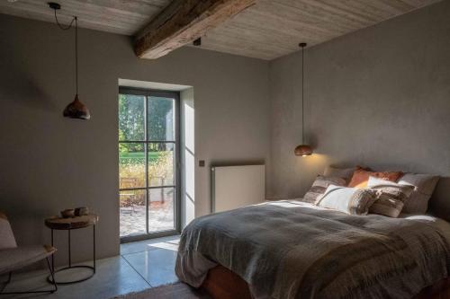 a bedroom with a bed and a large window at Chambres de Gilberoux in Floreffe