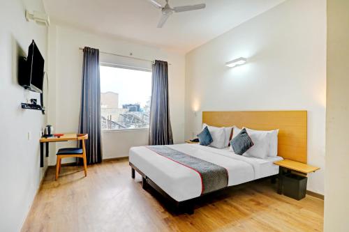 a hotel room with a bed and a window at Townhouse Sector Near Botanic Garden of Indian Republic in Noida