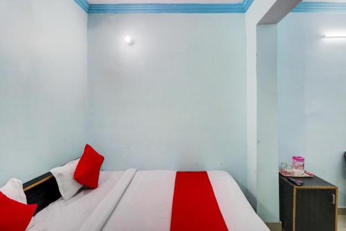 1 dormitorio con 1 cama con almohadas rojas en OYO Hotel Shiv Kripa en Kānpur