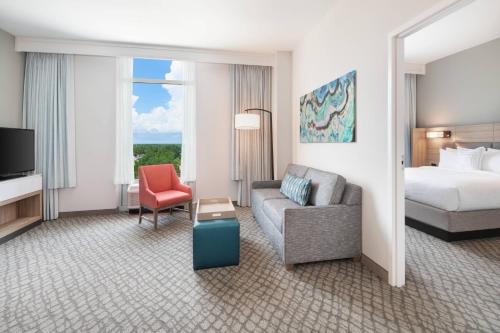um quarto de hotel com uma cama, um sofá e uma cadeira em SpringHill Suites by Marriott Panama City Beach Beachfront em Panama City Beach