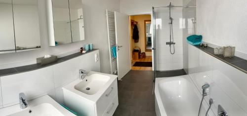 a white bathroom with a sink and a bath tub at RheinWeinBoppard 2 - mit Rheinblick in Boppard